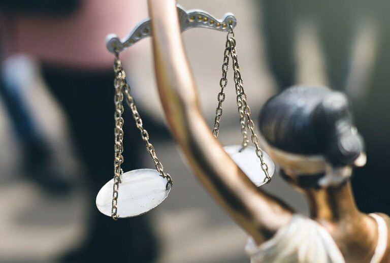 Justitia hält Waage hoch